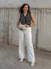 a lady wears a striped vest with a white wide leg trouser